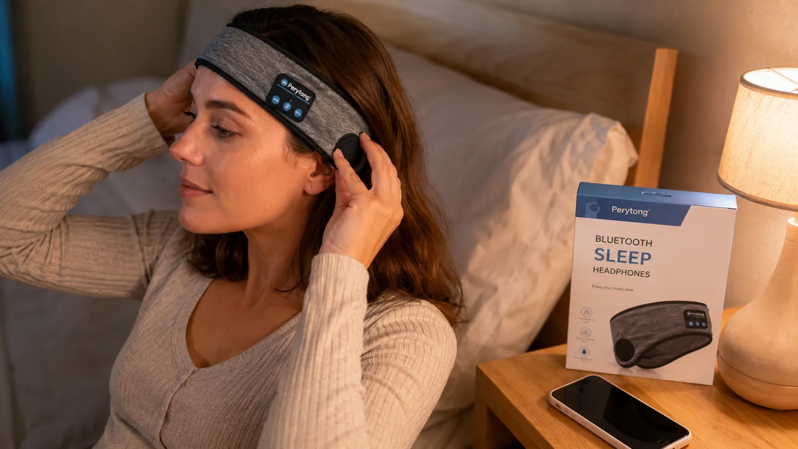Close-up of hands adjusting a Bluetooth sleep headband over the ears before bed
